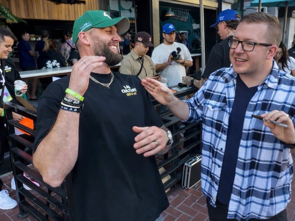 A guest cracks up as Tyler reacts during close-up magic at an outdoor event