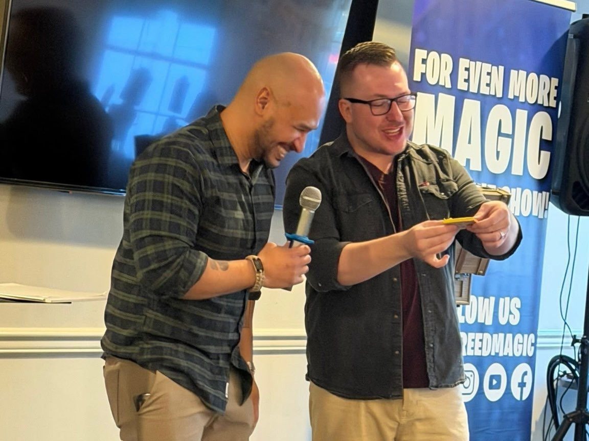 A volunteer laughs on stage as Tyler nails the card reveal