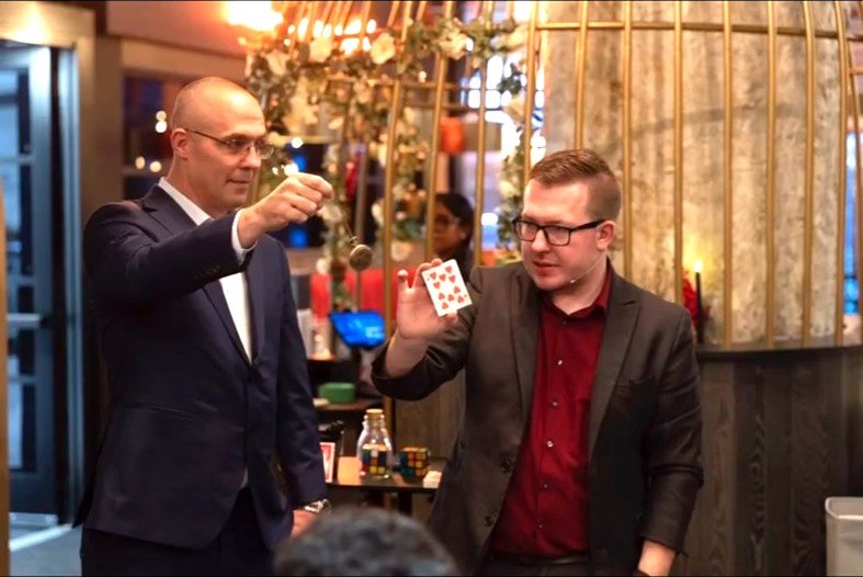 A playing card floats between Tyler and a stunned guest