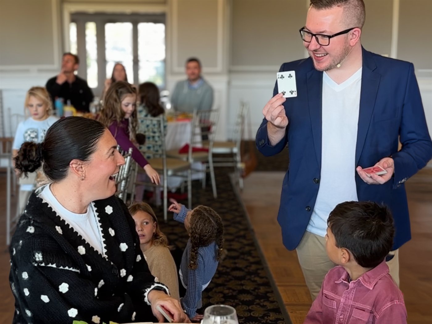 A member laughs in disbelief as Tyler reveals her card tableside in the club dining room