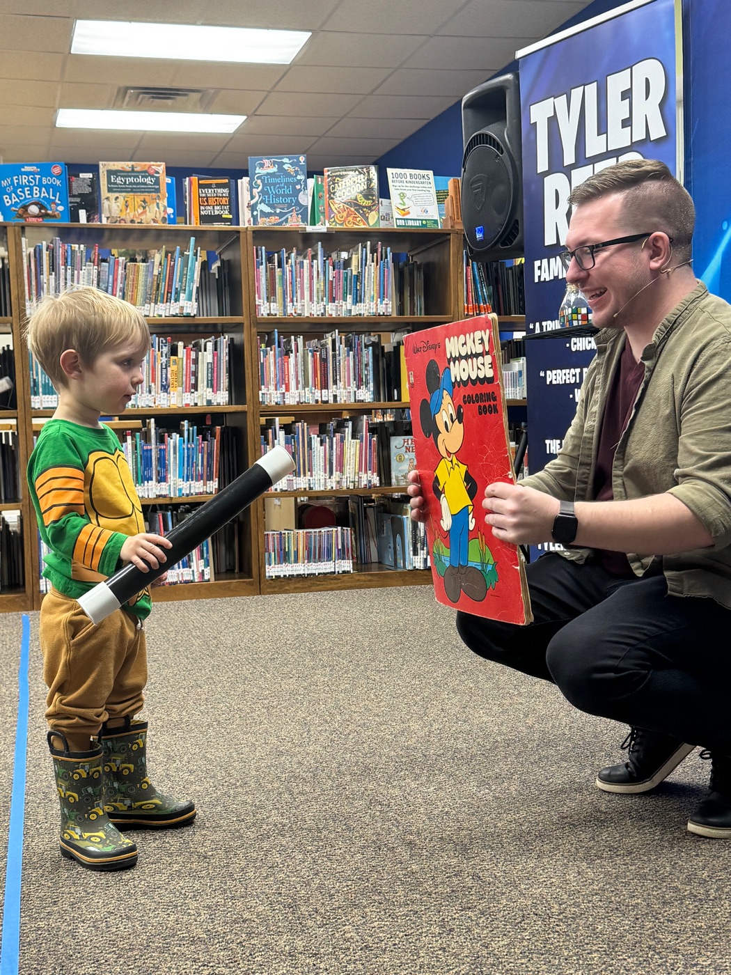 A young volunteer goes head to head with Tyler between the library stacks