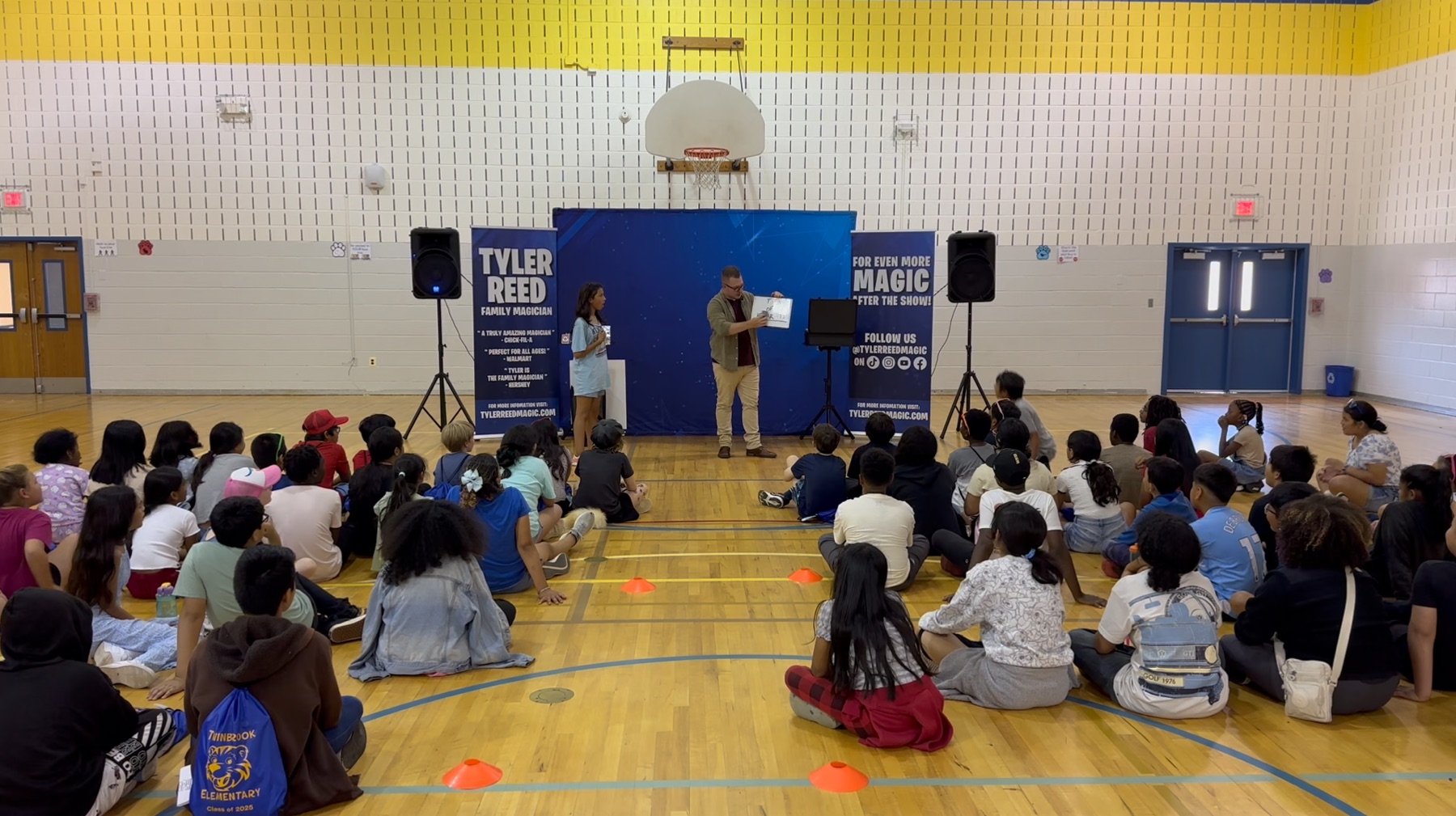 A full elementary school gym, every student locked on the show