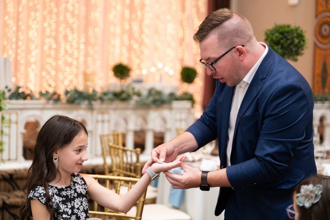 A young guest watches wide-eyed as Tyler performs a card trick